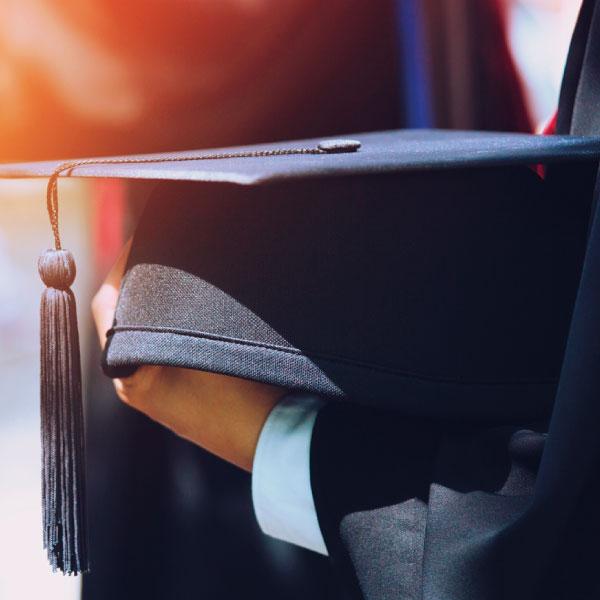 Mano sujetando un birrete de graduación