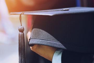 Mano sujetando un birrete de graduación