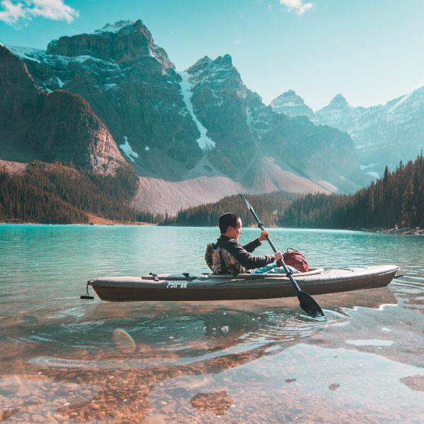 Chico en una piragüa sobre un lago de montaña